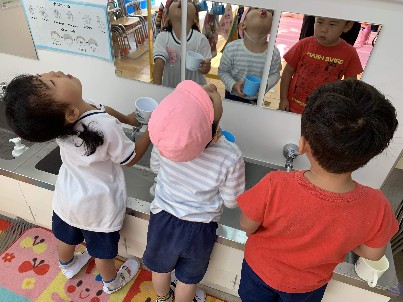 写真:並んで手洗いうがいをする子どもたち