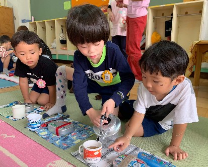 写真:麦茶を注ぐ子どもたち1