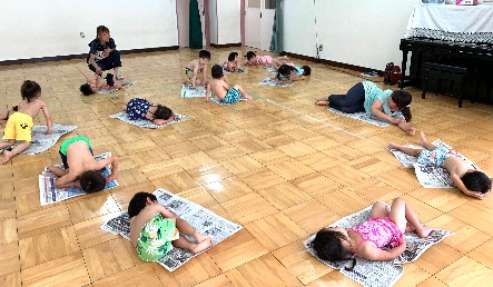 写真:新聞紙に寝転ぶ子どもたち