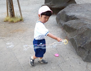 写真:シャボン玉で遊ぶ子ども