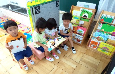 写真:絵本を友だちと一緒に読む子どもたち