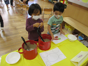 写真:お皿のシートに貼る子どもたち1