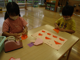 写真:折り紙できのこをつくる子どもたち