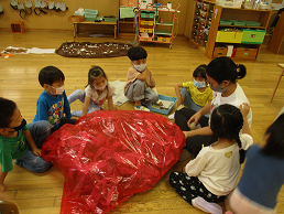 写真:おおきな赤いきのこの傘を作る子どもたち