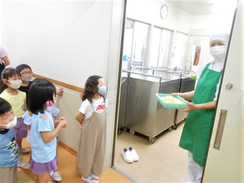 写真:ジャガイモを調理室へ運ぶ子どもたち