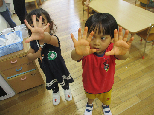 写真:手を見せる子どもたち