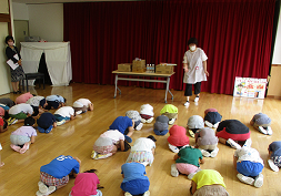 写真:体を丸める練習をする子どもたち