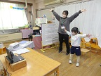 写真:大きく腕をのばす先生と子ども