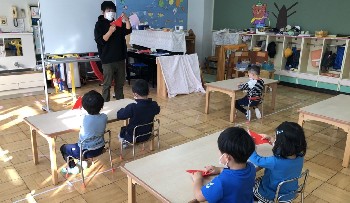 写真:間瀬先生から折り紙を教わる子どもたち