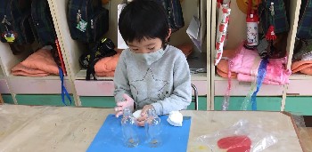 写真:瓶に紙粘土をつける子ども