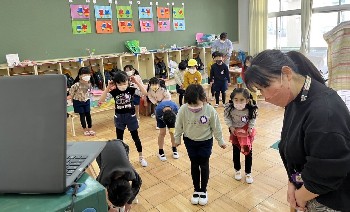 写真:オンライン出席の友だちとさよならじゃんけんをする子どもたち