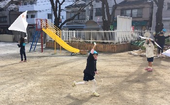 写真:元気に走って凧あげをする子どもたち