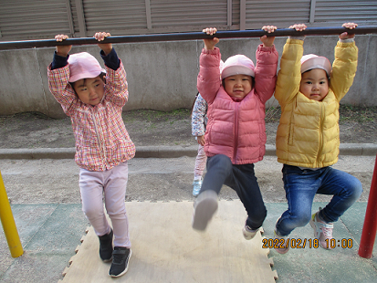 写真:鉄棒にぶら下がる子どもたち