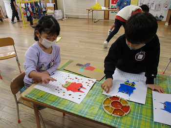 写真:折り紙を使って鬼を作る子どもたち