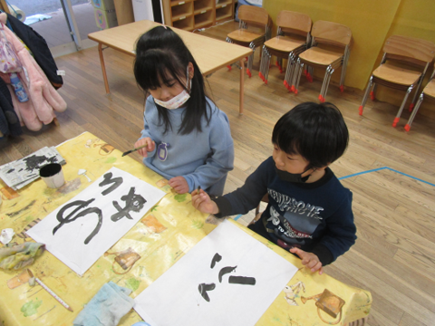 写真:墨で文字を書く子どもたち