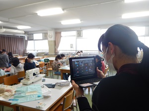 写真:先生ががタブレットを持って撮影する様子