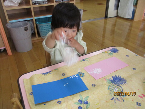 子どもがペットボトルと梱包材(プチプチ)を使って、スタンプで鱗模様を描いているところ