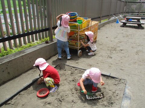 2才児が砂場で遊んでいる様子