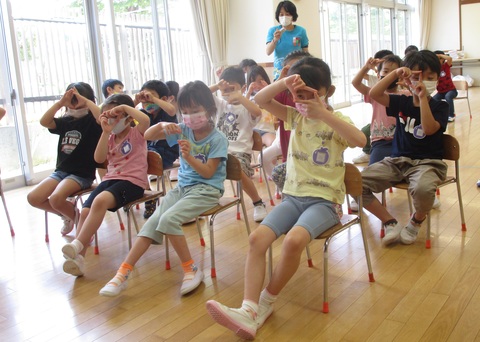 誕生児の写真を撮る真似をする子どもたち