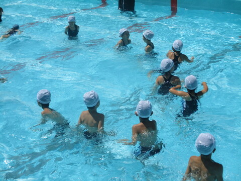 水泳指導を受ける児童の写真