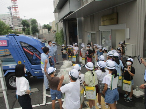 リサイクルセンターで清掃車体験をしている様子の写真