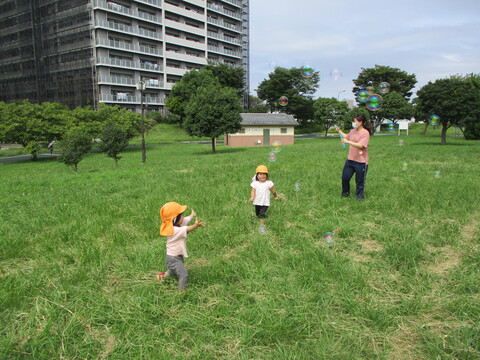 しゃぼん玉を割ろうとする子どもたち