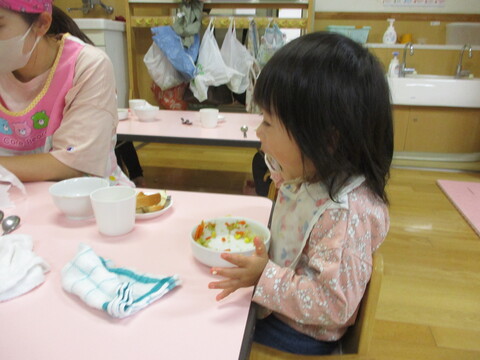 自分でスプーンを握り食べる子ども