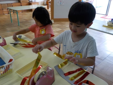 吹き流しを作る子どもの写真