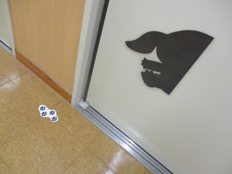 動物の体と足跡のシルエットが、保育室の扉に現れた写真