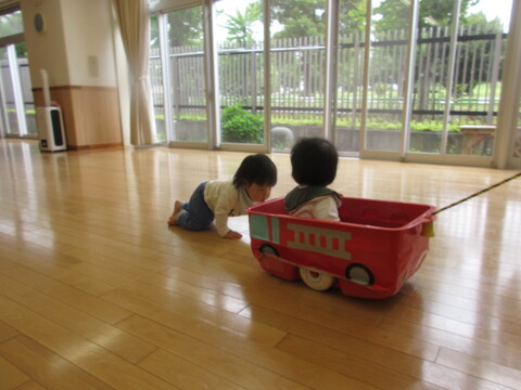 子どもたちが引き車で遊んでいる様子