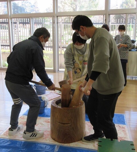 3人で杵をもって餅をついている