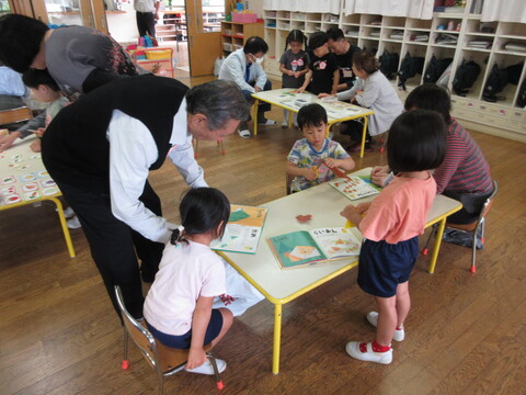 祖父母の方と園児で折り紙で遊んでいる様子