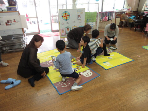 祖父母の方と園児でかるたで遊んでいる様子