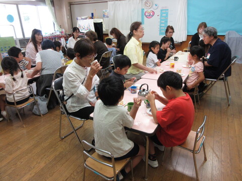 祖父母の方と園児でおせんべいを食べている様子